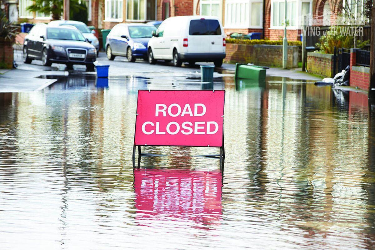 An image of a flooded road with a sign saying: Road Closed