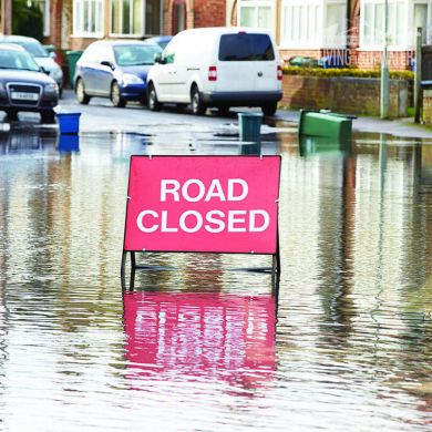 An image of a flooded road with a sign saying: Road Closed